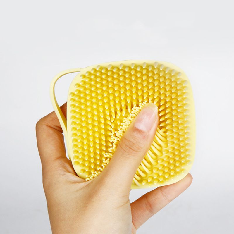 Flexible bristles on a yellow silicone pet bath brush