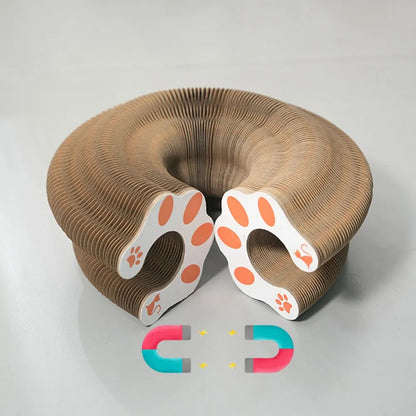 Accordion cat scratcher folded into a circular form, with paw-print end panels and magnetic closures shown.
