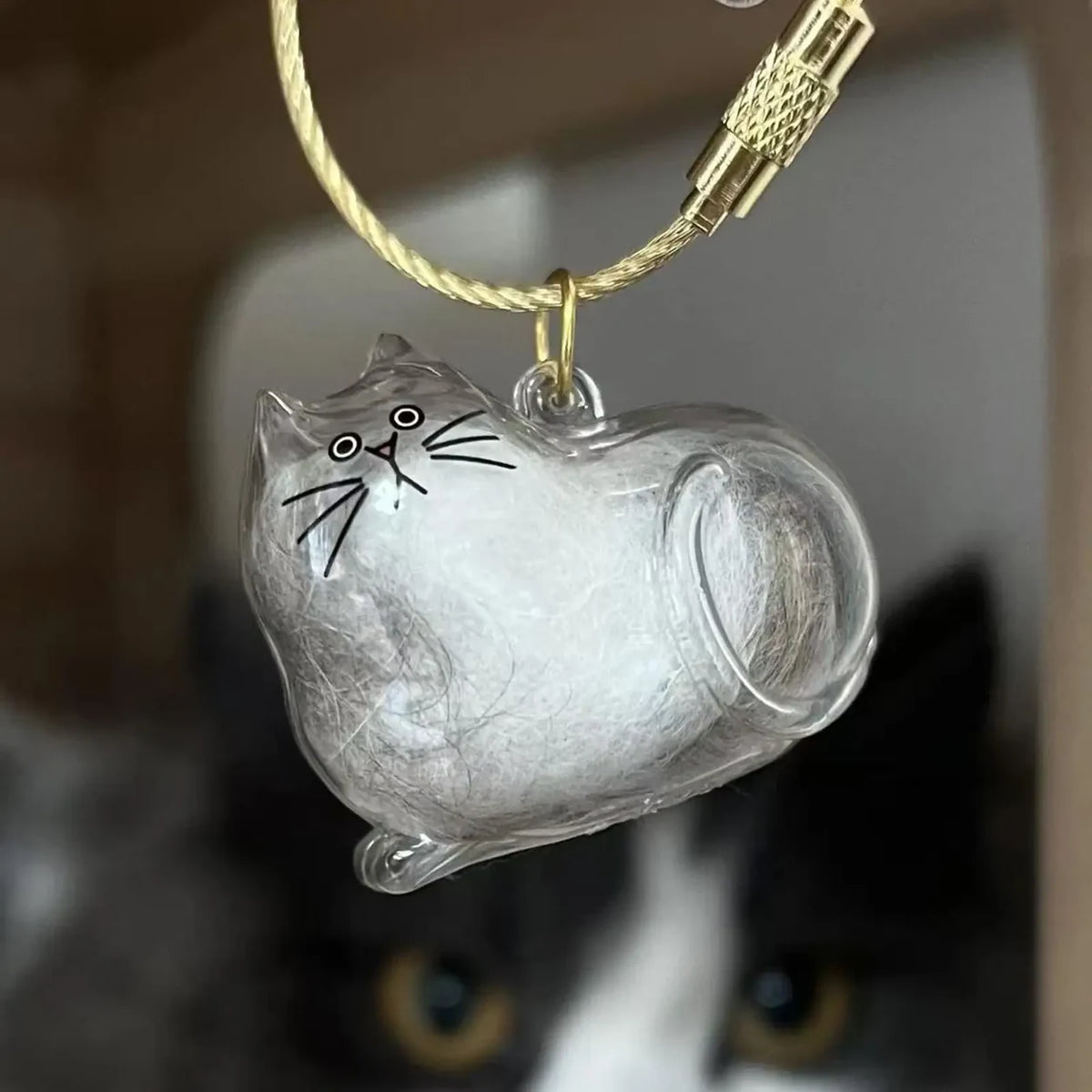 Silver Tabby cat-shaped keepsake keychain containing white fur, with a gold-tone loop attachment.