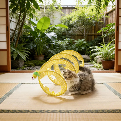 Cat playing inside a yellow collapsible spiral tunnel outdoors.
