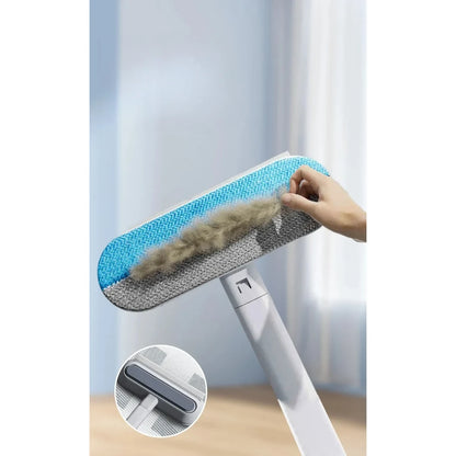 Hand lifting collected fur from the blue cleaning face of the long-handle pet hair removal tool.