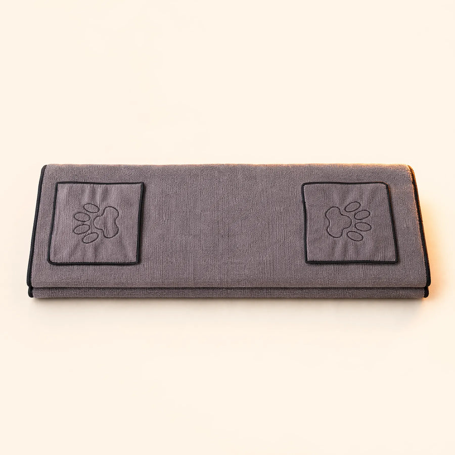 Folded gray pet drying towel with two paw-detail hand pockets and black edging.