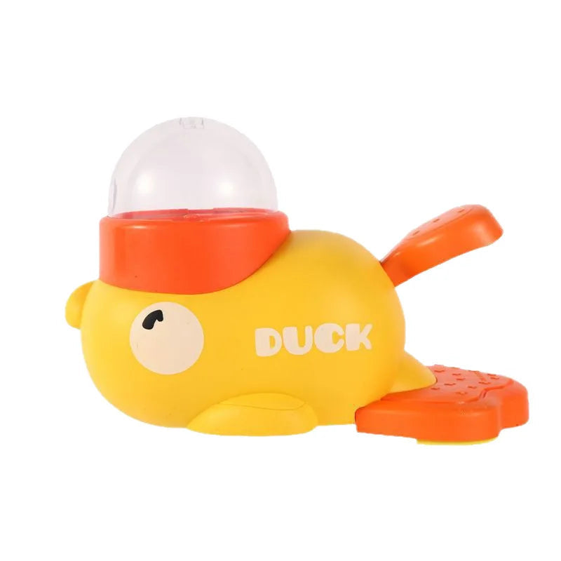 Yellow duck-shaped manual treat dispenser with an orange pedal and a clear food hopper.