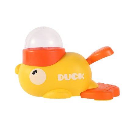 Yellow duck-shaped manual treat dispenser with an orange pedal and a clear food hopper.