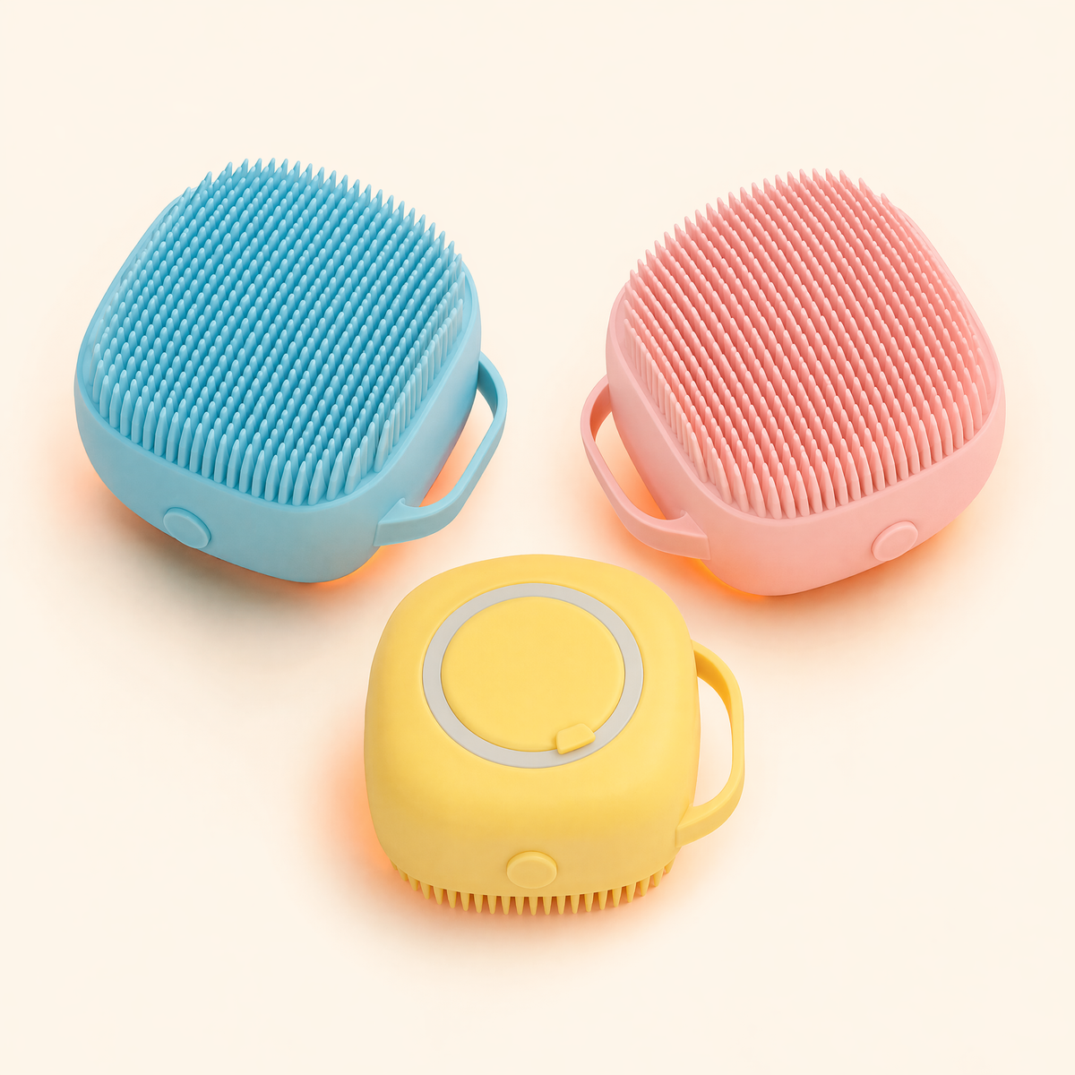 Blue, pink, and yellow silicone pet bath brushes with shampoo dispensers on a soft cream background