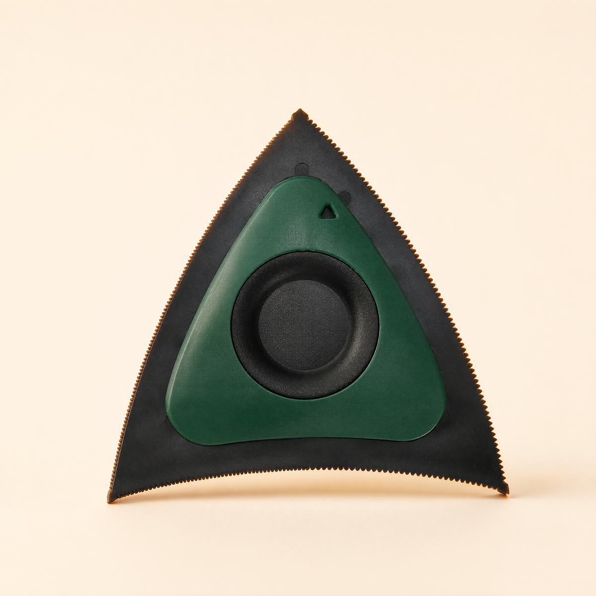 Green tri-edge pet hair scraper with black serrated edges on a soft cream background