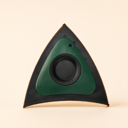 Green tri-edge pet hair scraper with black serrated edges on a soft cream background