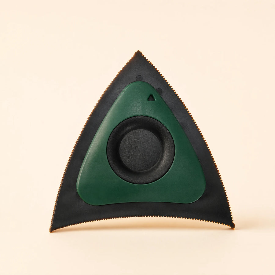Green triangular pet hair scraper with black edges and a circular center grip.
