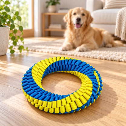 Single blue-and-yellow woven dog toy ring on a light wood floor with a dog nearby.