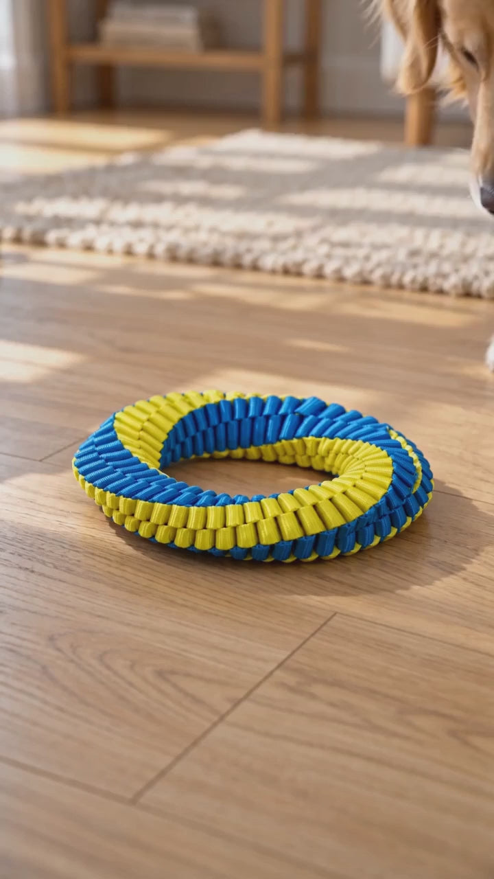 AI-generated product illustration: Single blue-and-yellow woven dog toy ring on a light wood floor with a dog nearby.
